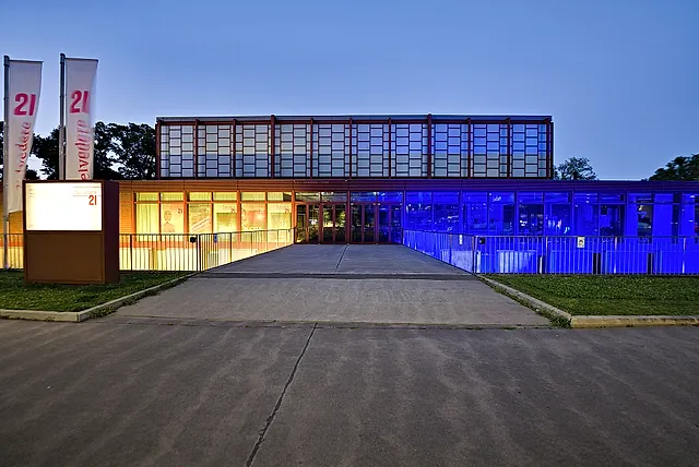 Il Belvedere 21 al crepuscolo, con la facciata di vetro illuminata di blu